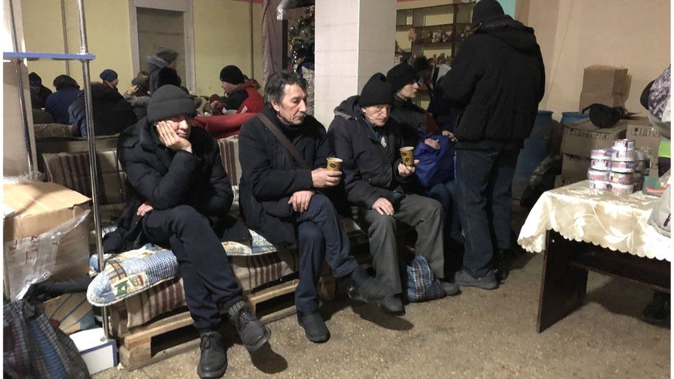 Men sit on a bench inside resilience centre in Bakhmut