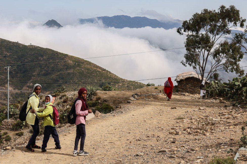 School children travel a path to their homes in the Durfo valley eight kilometers outside of the city of Asmara on December 30, 2022 in Asmara, Eritrea. The region is marked by high mountains and deep valleys which are often enveloped in thick clouds during midday as clouds make their way inland from the Red Sea and the port city of Massawa which is a few hours beyond Durfo by car.