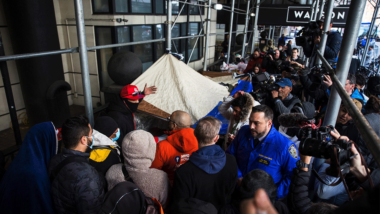 Migrants speak with NYC Homeless Outreach members as they camp out in front of the Watson Hotel after being evicted on January 30, 2023 in New York City. 