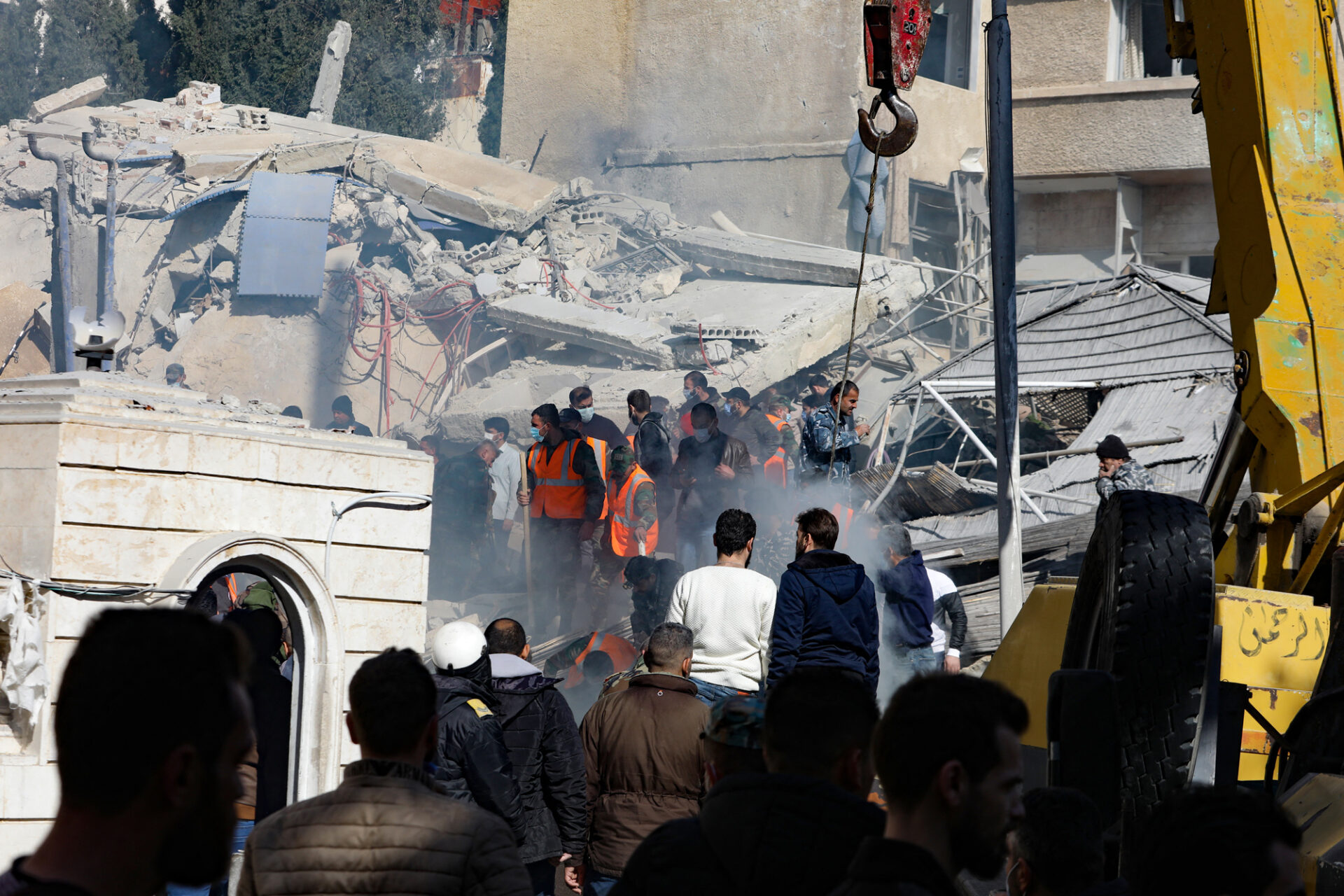 People and rescuers gather in front of a building destroyed in a reported Israeli strike in Damascus, Syria, on January 20.